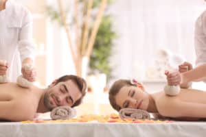 happy couple having massage in spa salon